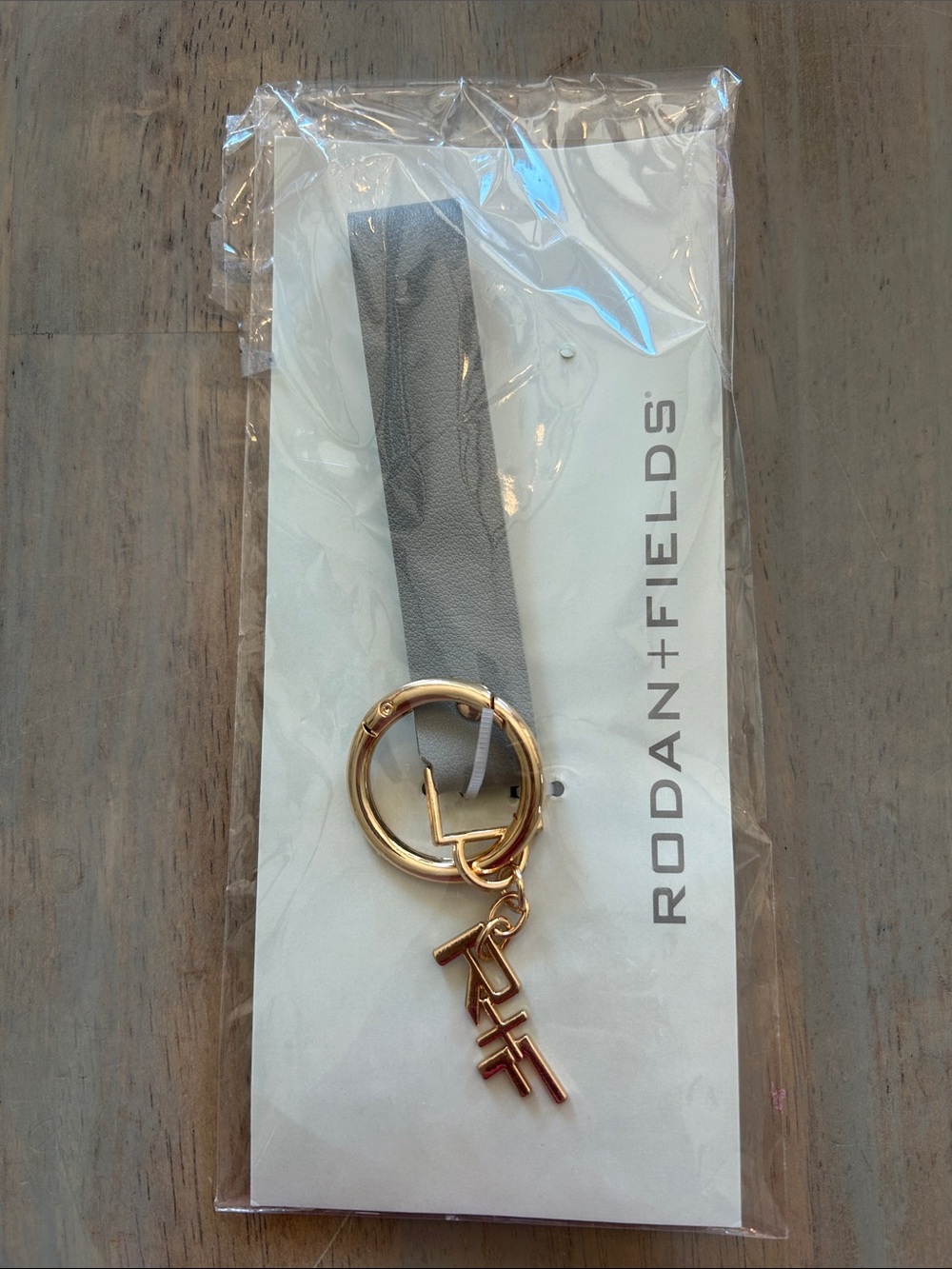 Rodan + Fields Gray Leather Strap Keychain with Gold Logo Charm